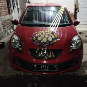 Bunga Mobil Pernikahan Tasikmalaya (mobil merah dengan rangkaian bunga putih kuning ungu dan pita)